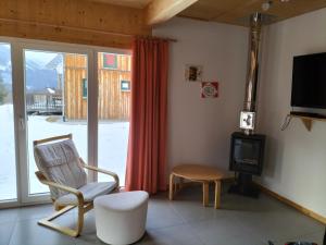 a living room with a chair and a television at Spatzennest in Hohentauern