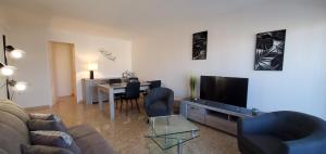 sala de estar con sofá, TV y mesa en Frejus Plage T1 35m2, climatise, 2 personnes,, en Fréjus