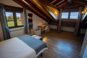sypialnia z łóżkiem, stołem i oknami w obiekcie La casita del abuelo w mieście Galizano