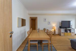una sala da pranzo con tavolo e sedie in legno di BeGuest Vasco da Gama Apartment a Lisbona