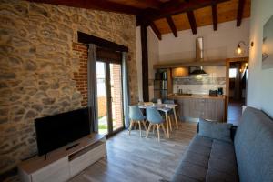 salon z kanapą i telewizorem oraz kuchnia w obiekcie La casita del abuelo w mieście Galizano