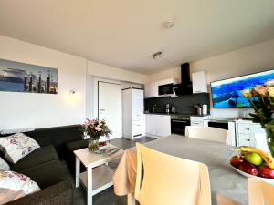 a living room and kitchen with a couch and a table at Ostsee-Fördeblick in Laboe