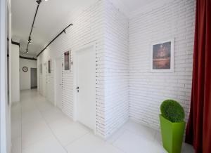 um corredor com paredes de tijolos brancos e uma planta verde em HELLO INN budget hotel em Astana