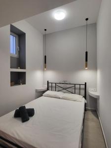 a bedroom with a white bed with a black headboard at Evangelia's Cozy House in Ermoupoli