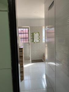 ein Bad mit einem Kühlschrank und Fliesenboden in der Unterkunft Apartamento familiar aconchegante in Maragogi