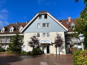 a large white building with a blue roof at Ostsee-Fördeblick in Laboe