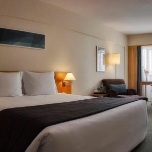 una habitación de hotel con una cama grande y una silla en Hotel & Residência Alphaville, en Barueri