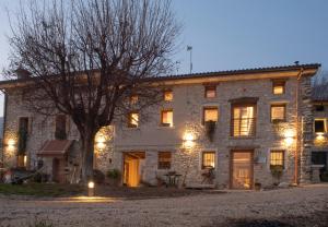 a stone building with a tree in front of it at Agriturismo Casaborgomarche in Valdobbiadene