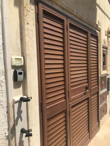 una porta di legno sul lato di un edificio di La dimora nel sottano alla strada a Polignano a Mare