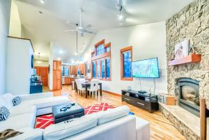 a living room with white furniture and a stone fireplace at Villa BG in Steamboat Springs