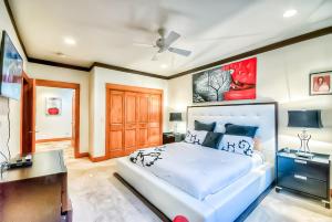 a bedroom with a white bed and a ceiling fan at Villa BG in Steamboat Springs
