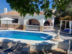 een villa met een zwembad en een huis bij Cortijo Kajo in Torrox