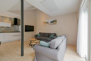 een woonkamer met een bank en een tv bij Vakantiehuis Vicky - Julianadorp aan Zee in Julianadorp