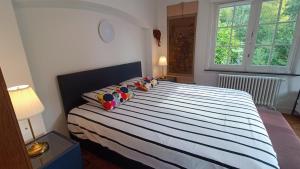 1 dormitorio con 1 cama grande con sábanas y almohadas a rayas en HIDDEN GEM Centre of BRUGES free PARKING, en Brujas