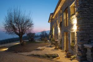 um edifício de pedra com uma árvore em frente em Agriturismo Casaborgomarche em Valdobbiadene