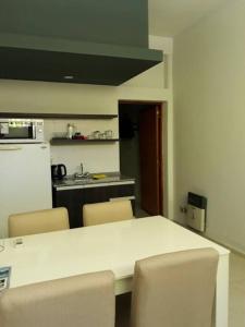a kitchen with a white table with chairs and a refrigerator at Alquiler en San Rafael in San Rafael