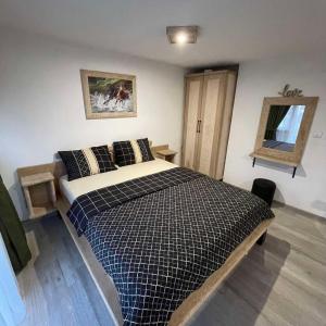 a bedroom with a bed with a black and white comforter at Apartman Anna Budva in Budva