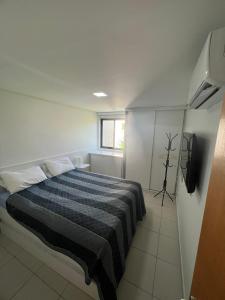 sypialnia z łóżkiem i telewizorem w obiekcie Carneiros Beach Resort 119-E w mieście Tamandaré
