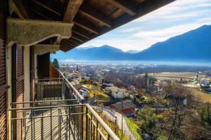 Elle comprend un balcon offrant une vue sur la ville et les montagnes. dans l'établissement Lilia Apartment by Quokka 360 - large flat with panoramic view of Locarno, à Gordola