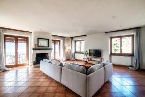 a living room with a couch and a television at Lilia Apartment by Quokka 360 - Bright Spacious Flat with Panoramic Locarno View in Gordola
