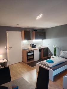 ein Wohnzimmer mit einem Bett und eine Küche in der Unterkunft Stadtnah an der Förde 7 HH L 1OG in Flensburg