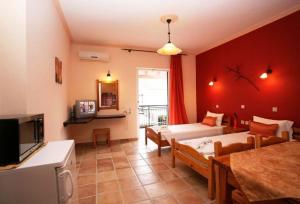 a living room with a couch and a bed and a tv at Apartments Corfu Sun Sea Side in Benitses