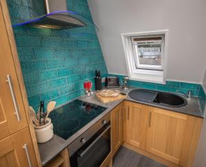 a kitchen with a sink and a counter top at Loft Apartment, Keswick in Keswick