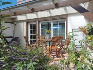 un patio con mesa y sillas en un jardín en Haus 1795 Sperber, en Wustrow