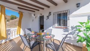 comedor con mesa y sillas en el balcón en Casa Maite Sol Nerja by Ruralidays, en Nerja