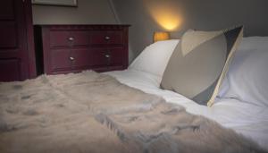 a large white bed with a pillow and a dresser at Loft Apartment, Keswick in Keswick