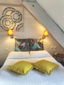 a bedroom with a bed with two pillows at Logis HOTEL RESTAURANT La Régence in Cherbourg en Cotentin