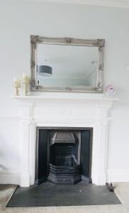 a fireplace with a mirror on top of it at Holbein House in Penzance