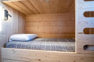 uma sauna com uma cama num camarote de madeira em Comfortable studio with balcony - Huez - Welkeys em LʼHuez