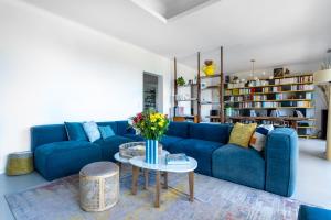 a living room with a blue couch and a table at Villa Moderniste d'architecte vue mer in Toulon