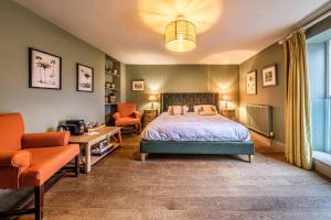 um quarto com uma cama, uma secretária e cadeiras em The Globe Inn em Wells-next-the-Sea