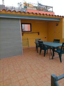 un patio con tavolo, sedie e garage di Preciosa casa de 2 pisos a 50 metros de la playa a Canet de Mar