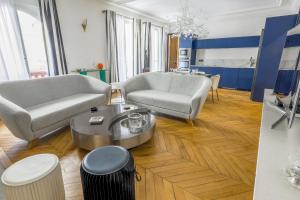 Una sala de estar con dos sofás y una mesa. en Appartement du Pilot - Welkeys, en Neuilly-sur-Seine