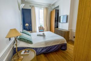 Una habitación de hotel con una cama con un animal de peluche encima. en Appartement du Pilot - Welkeys, en Neuilly-sur-Seine