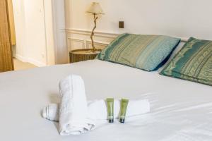 Una cama blanca con toallas y almohadas. en Appartement du Pilot - Welkeys, en Neuilly-sur-Seine 4 fotos más