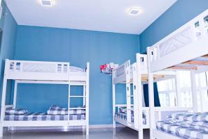 2 literas en una habitación con paredes azules en Hawana Hostel en Dubái