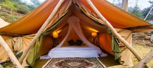 a tent with a bed inside of it at Neerville Waterfall Glamping- Neer waterfall in Shivpuri