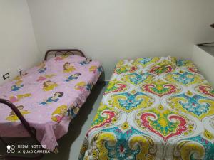 dos camas sentadas una al lado de la otra en una habitación en HERMOSO APARTAMENTO CON TERRAZA, en Ibagué