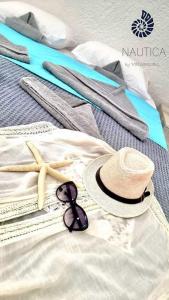 a pair of sunglasses and a hat and a pair of towels at Nautica by Valsamidis in Vlychádia