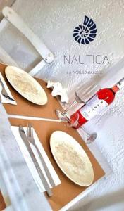 a table with plates and utensils on a table at Nautica by Valsamidis in Vlychádia