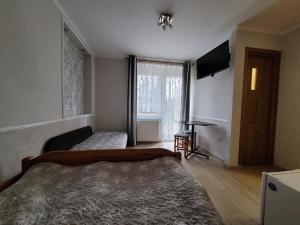1 dormitorio con 2 camas y TV. en Przy Deptaku, en Mielno