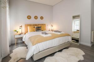 a bedroom with a large bed and a mirror at Viana Central - Historical City Centre Apartment in Viana do Castelo