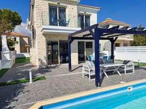 a villa with a swimming pool and a house at Villa Sunshine in Mazotos