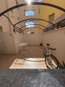 een fiets geparkeerd in een kamer met een gebouw bij Civico 8bis Casa Vacanze in Alghero