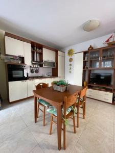 een keuken met een houten tafel en stoelen in een kamer bij Civico 8bis Casa Vacanze in Alghero