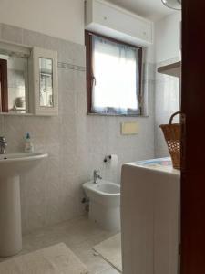 een witte badkamer met een wastafel en een toilet bij Civico 8bis Casa Vacanze in Alghero